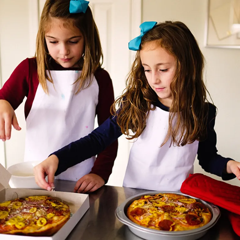 Two girls baking for a fundraiser.